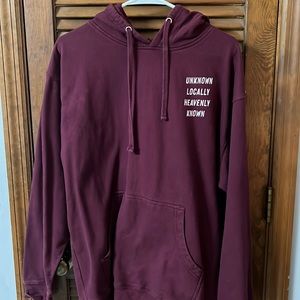 Unisex burgundy hoodie with great saying “unknown locally heavenly known “.